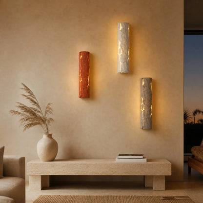 Trois appliques murales pierre de lave, finitions terracotta, pierre claire et gris pierre, dans un salon | Delvanie