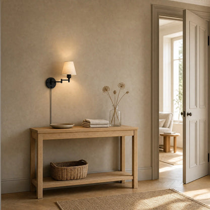 Applique murale tissu allumee au-dessus d'une console en chene dans une entree