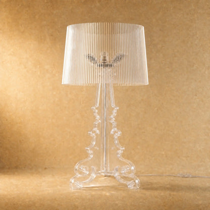Lampe baroque Rivento en acrylique transparent, colonne à volutes et abat-jour cannelé, vue de face