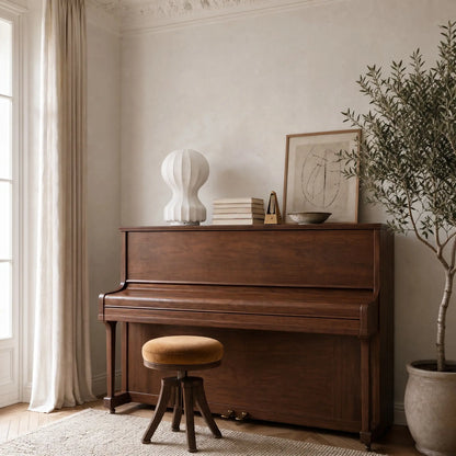 Lampe d'ambiance cocon posee sur un piano droit en noyer, en plein jour | Delvanie