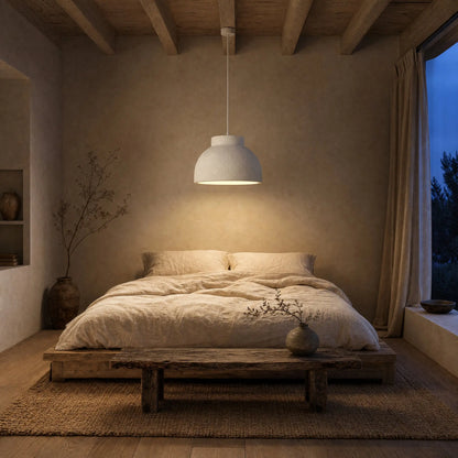 Lustre Nivoya allumé au-dessus du lit dans une chambre wabi-sabi au crépuscule | Delvanie