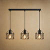 Lustre cuisine Feroya, trio de cages noires en fer, fond minéral beige | Delvanie