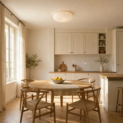 Plafonnier Celestra blanc au-dessus d'une table ronde en bois dans une cuisine ensoleillée