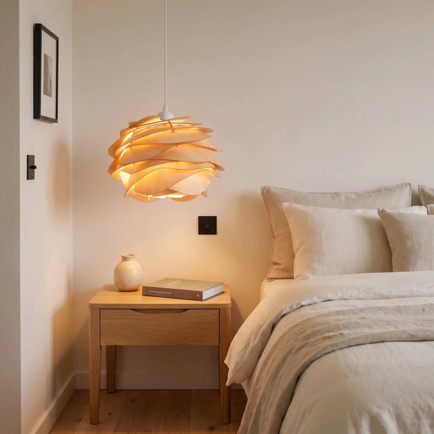 Suspension bois sculptée Rozenya éclairant une table de chevet dans une chambre