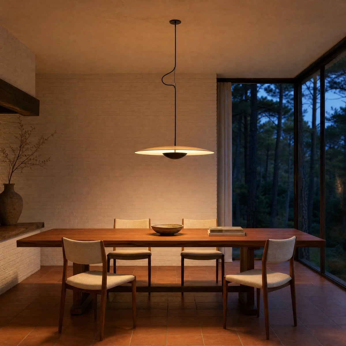 Suspension effet bois allumée au-dessus d'une table de teck dans une salle à manger d'architecte