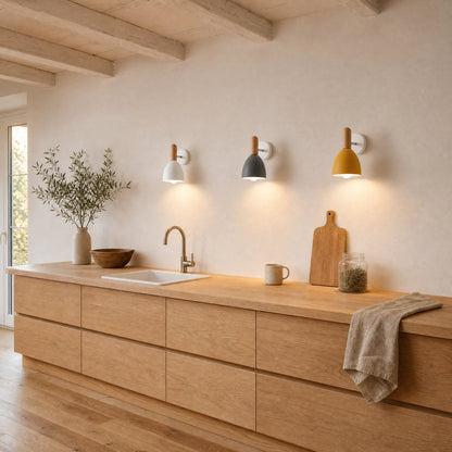 Trois appliques murales scandinaves blanche, grise et jaune alignées au-dessus d'un plan de travail en chêne | Delvanie