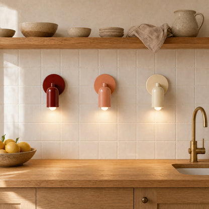 Trois appliques murales Nolvina creme, terracotta et rouge brique alignees au-dessus d'un plan de travail | Delvanie