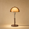 Lampe abat-jour à grande coupole d'ambre allumée, pied de fer à finition noyer | Delvanie
