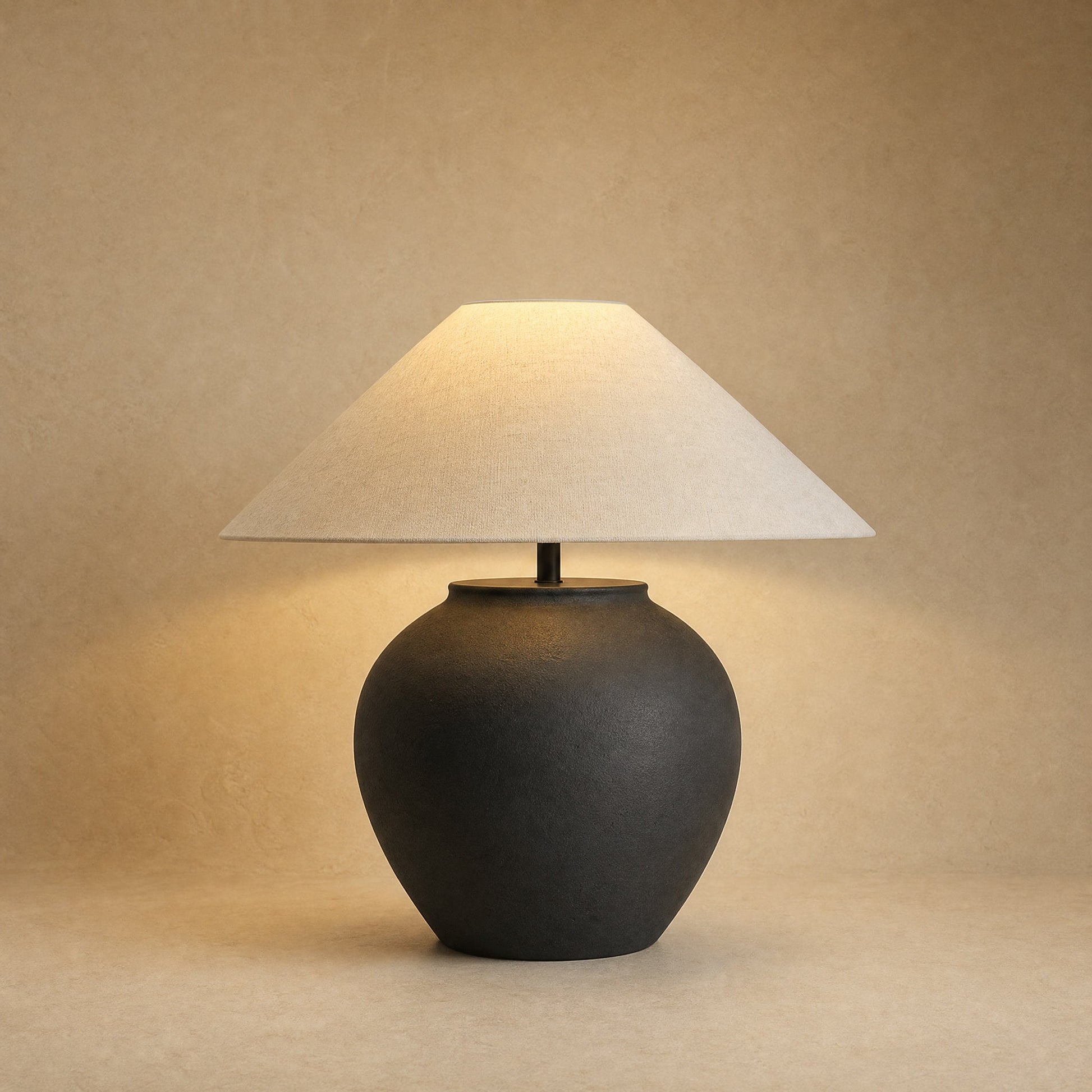 Lampe céramique à poser, jarre noire mate et large abat-jour écru, allumée | Delvanie