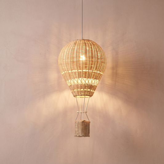 Suspension enfant rotin montgolfière LED dimmable Ballora, allumée sur fond rose-beige
